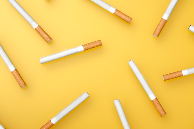 Uma imagem superior de vários cigarros. Postura plana. Cigarros em amarelo.