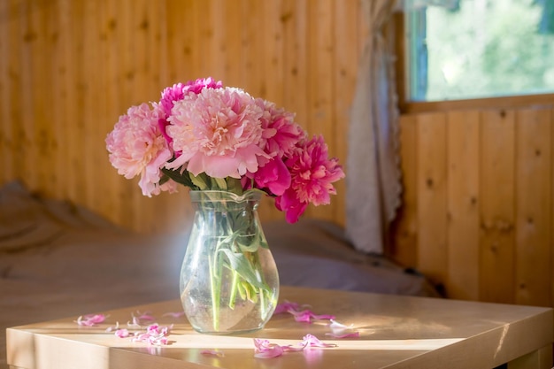 Uma janela brilhante com flores, uma xícara de café e um livro no peitoril da janela