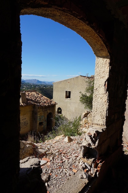 Uma janela em um prédio com vista para as montanhas ao fundo.