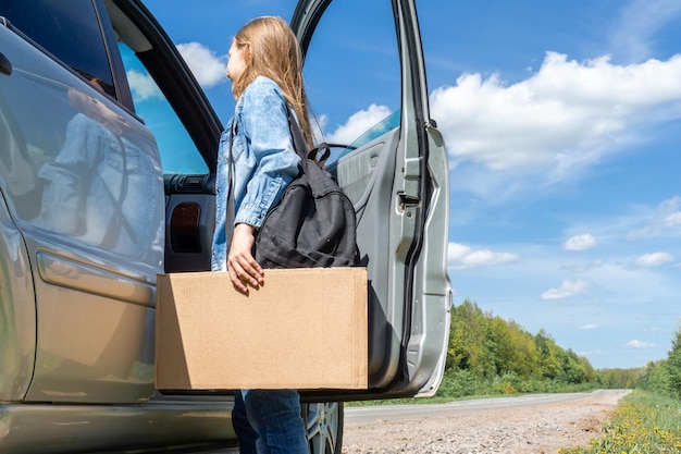 Uma jovem adolescente com uma mochila pedindo carona parou o carro para uma viagem conversando com o dr