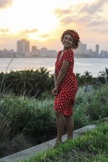 Uma jovem afro gosta da natureza em um parque natural A garota é jovem e sorri para a câmera