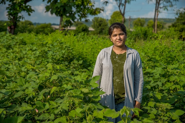 Uma jovem agricultora em um campo de cultivo de algodão.