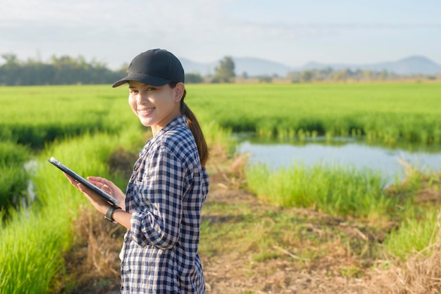 Uma jovem agricultora inteligente com tablet no campo, inovações de alta tecnologia e agricultura inteligente