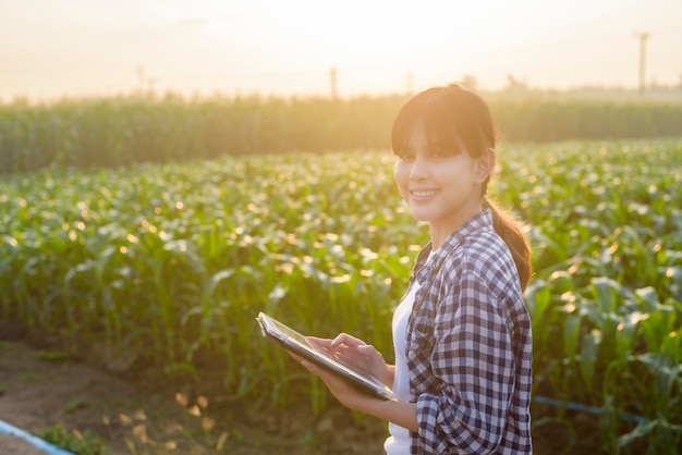 Uma jovem agricultora inteligente com tablet no campoInovações de alta tecnologia e agricultura inteligente