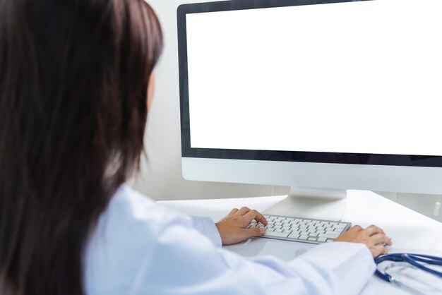 Uma jovem asiática bonita conferência de videochamada on-line sente-se, ouça o paciente para explicar no monitor do computador de mesa frontal, quarentena, doença, coronavírus ou COVID-19, no escritório do hospital