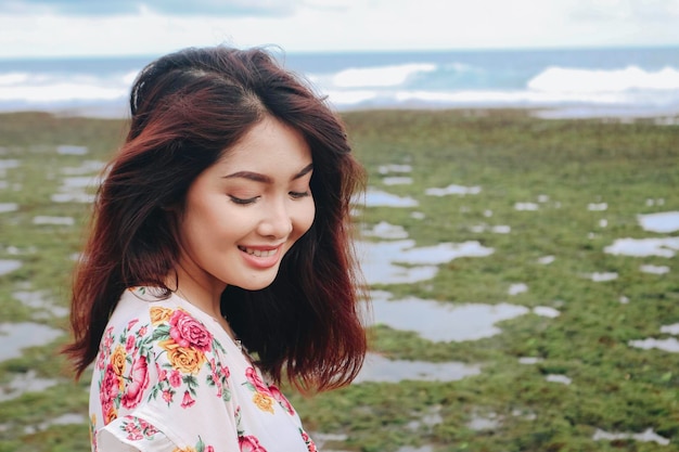 Uma jovem asiática na praia está sorrindo para a câmera em Gunungkidul Indonésia