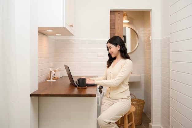Uma jovem asiática usando laptop online trabalhando em casa, estilo de vida e conceito de teletrabalho