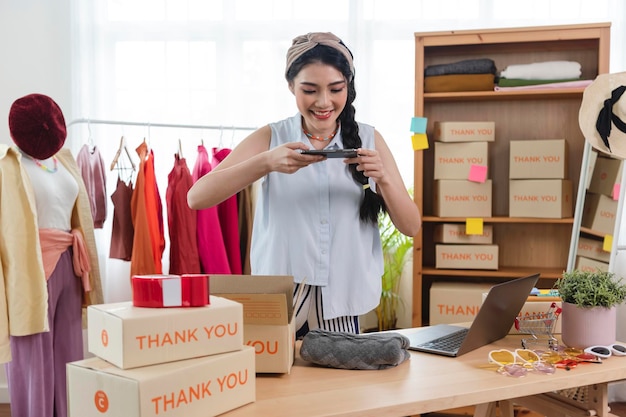 Uma jovem asiática vende um empresário de roupas que trabalha em casa, um pequeno empresário PME