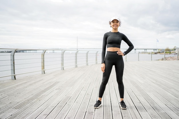 Uma jovem atleta faz exercícios de treino ativo de fitness para cardio usa um rastreador de relógio inteligente na mão