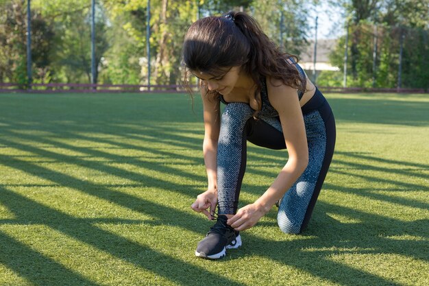 Uma jovem atlética magra em roupas esportivas com estampas de pele de cobra realiza um conjunto de exercícios Fitness e estilo de vida saudável