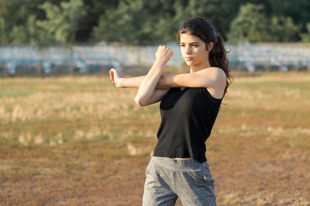 Uma jovem atlética magra em roupas esportivas com estampas de pele de cobra realiza um conjunto de exercícios Fitness e estilo de vida saudável