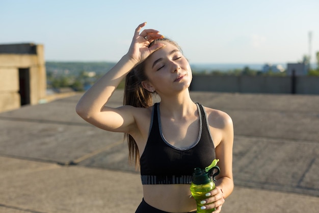 Uma jovem atlética magro em roupas esportivas realiza um conjunto de exercícios.