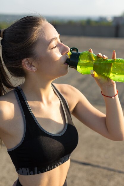 Uma jovem atlética magro em roupas esportivas realiza um conjunto de exercícios.