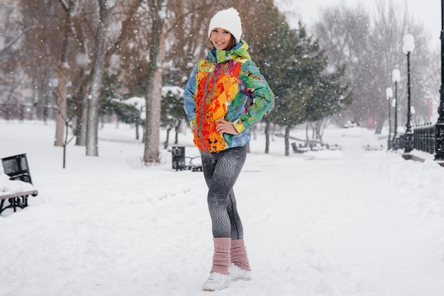 Uma jovem atlética posa em um dia gelado e com neve. Fitness, corrida