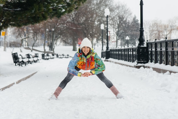 Uma jovem atlética pratica esportes em um dia gelado e com neve. fitness, corrida