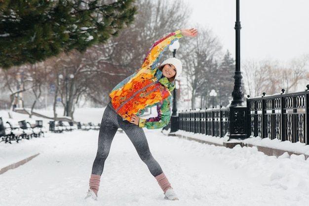 Uma jovem atlética pratica esportes em um dia gelado e com neve. Fitness, corrida