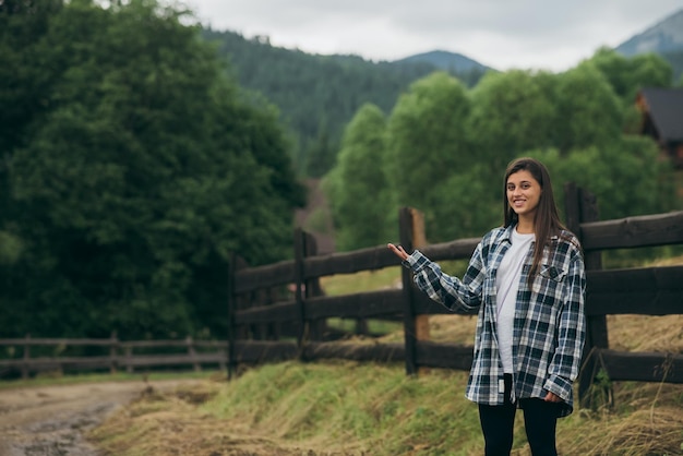 Uma jovem atraente caucasiana sentada em cima do muro e posando para a câmera