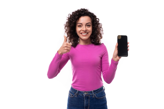 Foto uma jovem bonita com cabelos encaracolados mostrando a tela do telefone