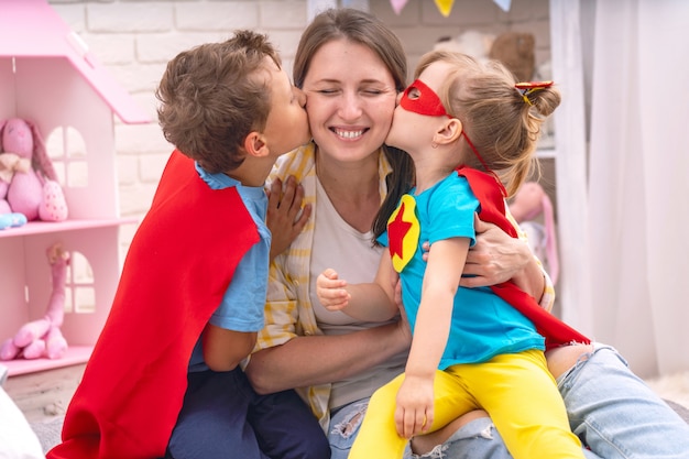 Uma jovem brinca com seus filhos em super-heróis