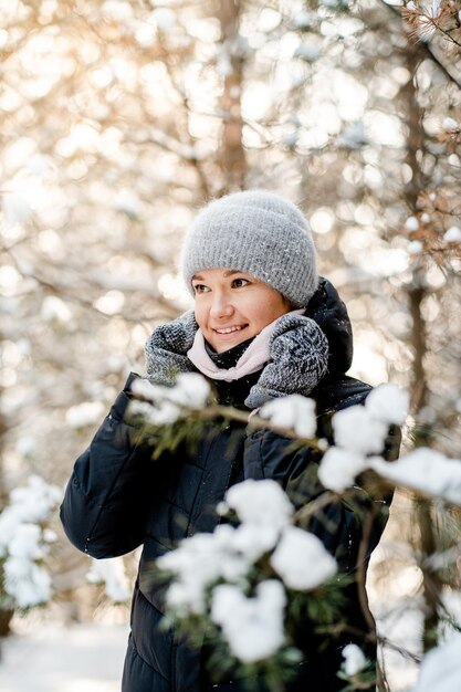 Uma jovem caminha em um parque nevado de inverno em um dia ensolarado de molar Férias de inverno ativas Estilo de vida saudável