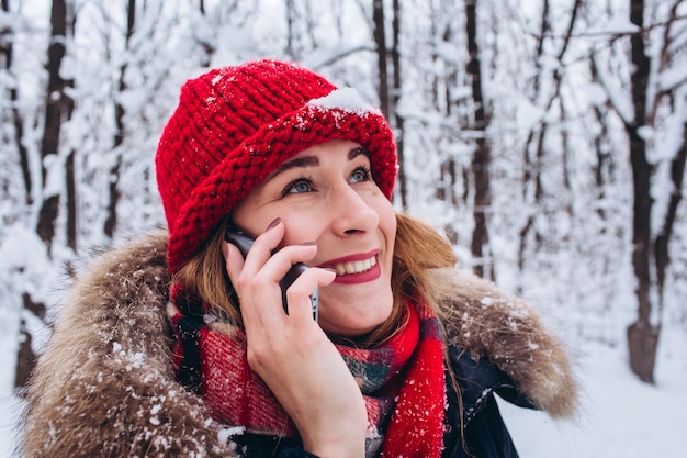 Uma jovem caminha em uma floresta de neve no inverno