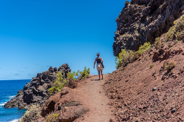 Uma jovem caminhando pelo caminho no verão até a praia de Nogales