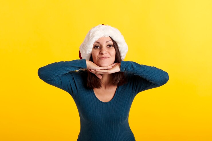 Foto uma jovem caucasiana com um chapéu de papai noel olhando para a câmera
