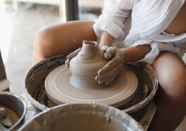 Uma jovem ceramista senta-se atrás de uma roda de oleiro Artesanato