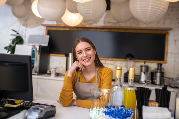 Uma jovem charmosa trabalhando como barista em um café