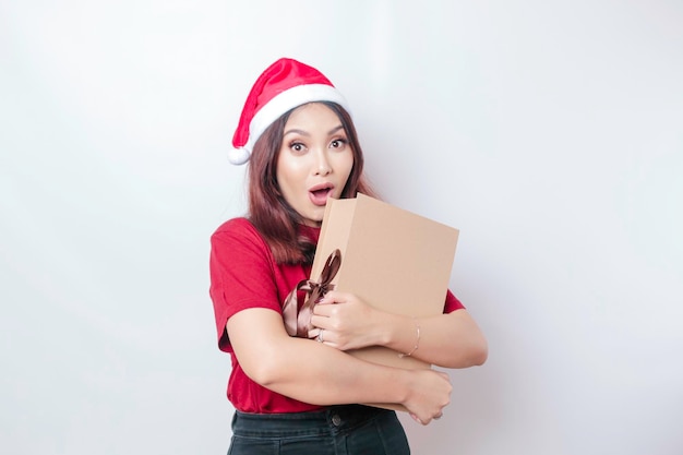 Uma jovem chocada está usando chapéu de Papai Noel39 e segurando presentes de Natal