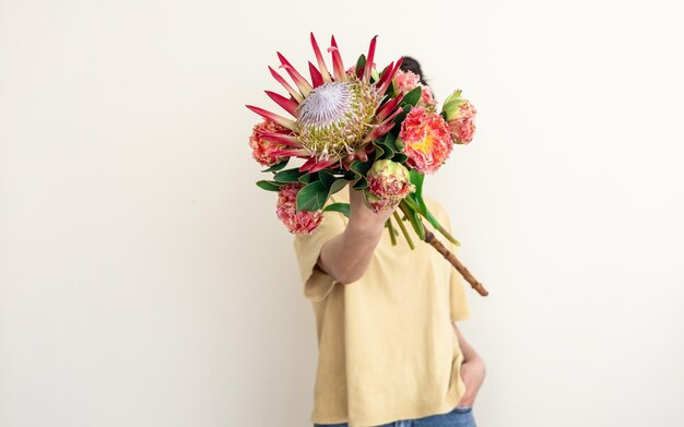 Uma jovem com flor de protea em um fundo branco