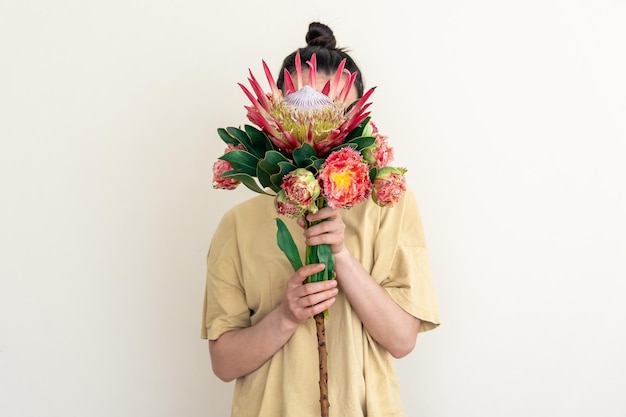 Uma jovem com flor de protea em um fundo branco