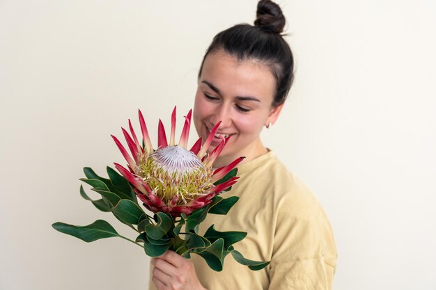 Uma jovem com flor de protea em um fundo branco