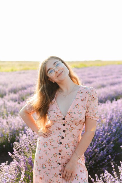 Uma jovem com óculos de manhã em um campo de lavanda