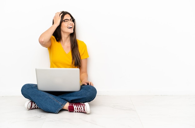 Uma jovem com um laptop sentada no chão percebeu algo e pretende encontrar a solução