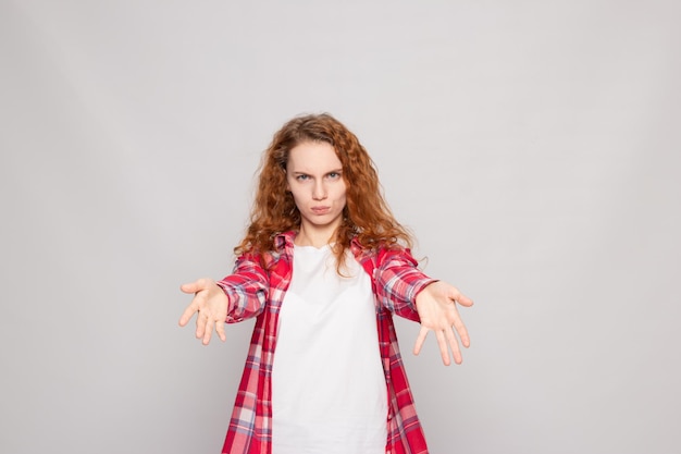 Uma jovem com uma camisa xadrez abraços em um fundo claro