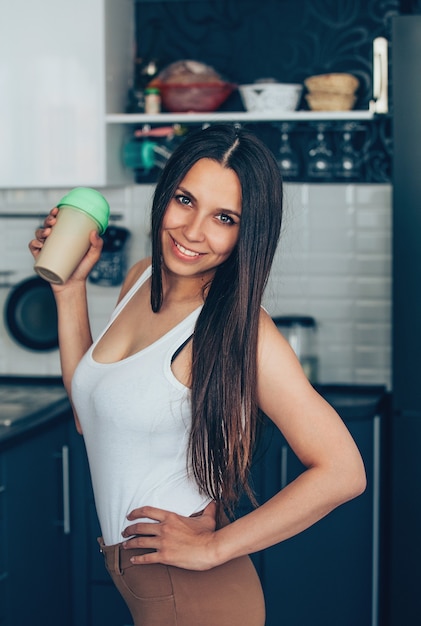 Uma jovem com uma jarra na cozinha