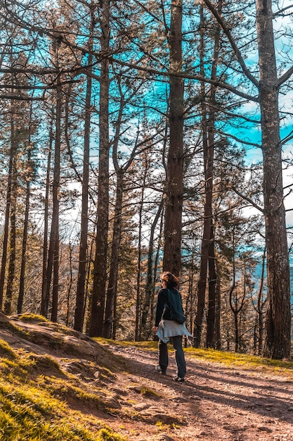 Uma jovem com uma mochila caminhando pelo caminho do Monte Adarra