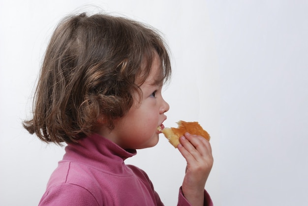 Uma jovem comendo um pão