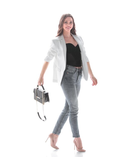 Uma jovem confiante com uma bolsa graciosa avança isolada em foto branca com espaço de cópia
