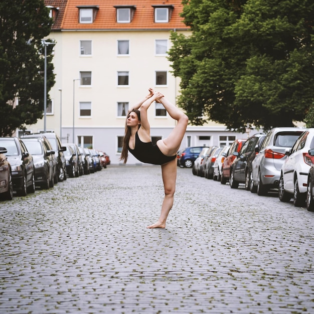 Uma jovem dançarina de ballet despreocupada a exercitar-se na rua da cidade.