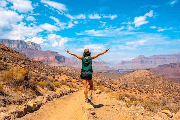 Uma jovem de braços abertos na trilha South Kaibab Trailhead Grand Canyon