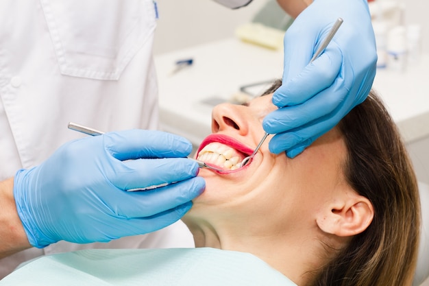 Uma jovem de cabelos escuros visita o dentista.