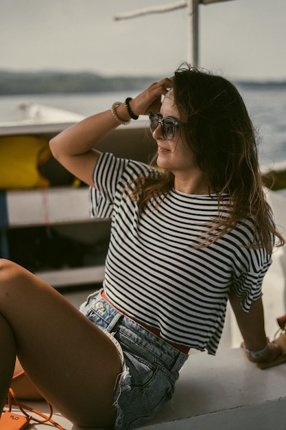 Uma jovem de óculos de sol viaja em um barco no oceano.