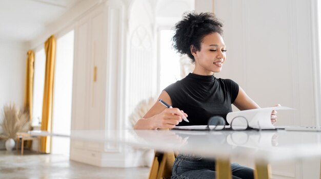 Uma jovem de óculos é uma funcionária da empresa online trabalhando em um escritório em um espaço de coworking