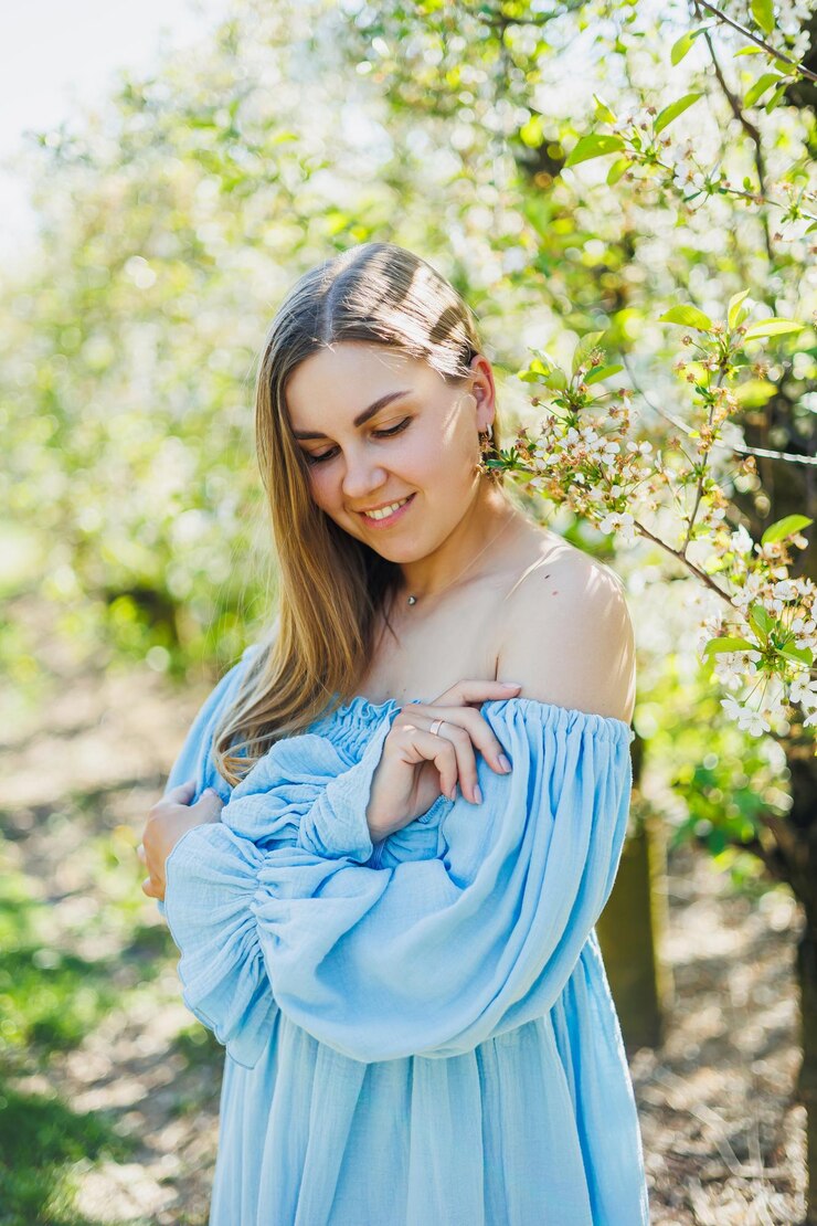 Foto uma jovem de vestido azul claro num jardim em flor uma linda mulher a passear no jardim