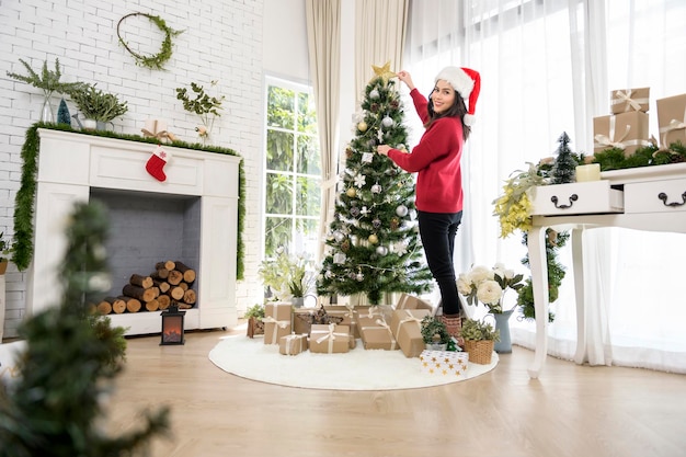 Uma jovem desfrutando com decorações de Natal em casa