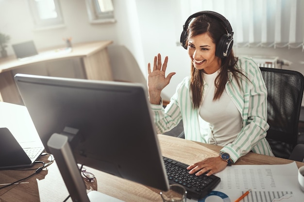 Foto uma jovem designer feminina de sucesso está trabalhando em um novo projeto no escritório.