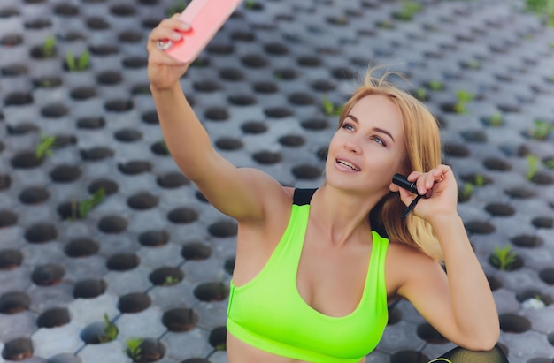 Foto uma jovem e bonita instrutora de ioga a liderar uma aula online. uma jovem a praticar ioga com o telemóvel.