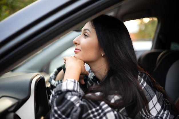 Uma jovem e linda motorista se senta ao volante de seu carro Uma senhora moderna Uma viagem uma viagem Estilo de vida